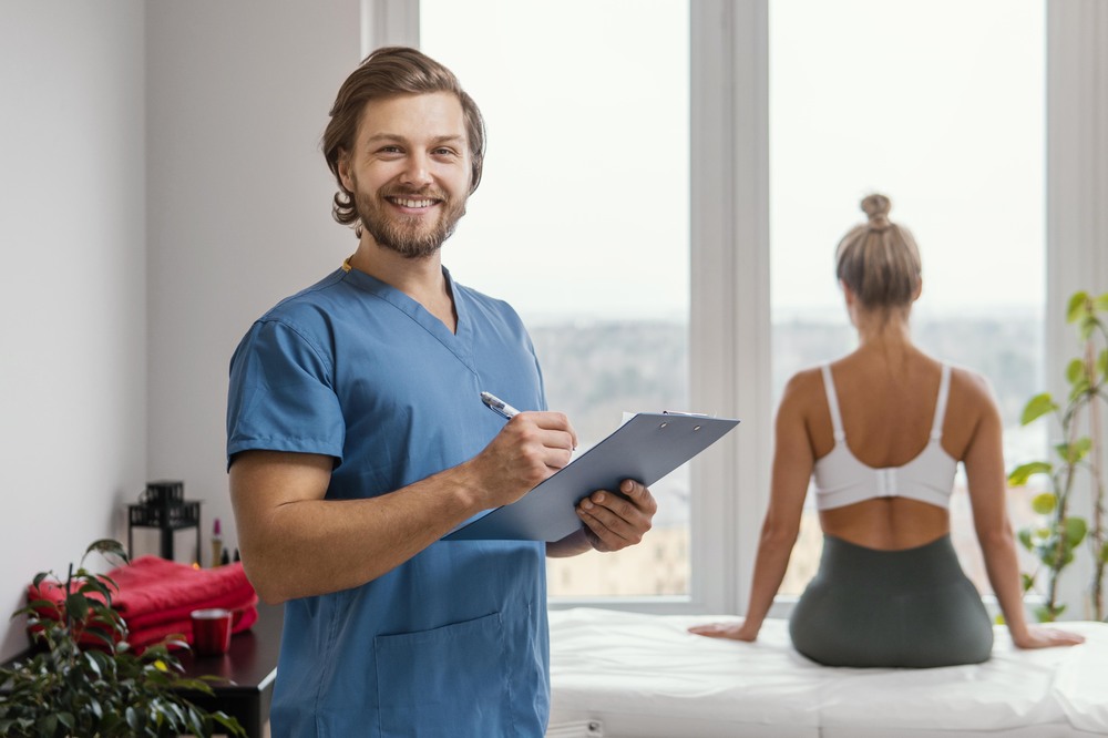 smiley-male-osteopathic-therapist-with-clipboard-female-patient-clinic-1.jpg