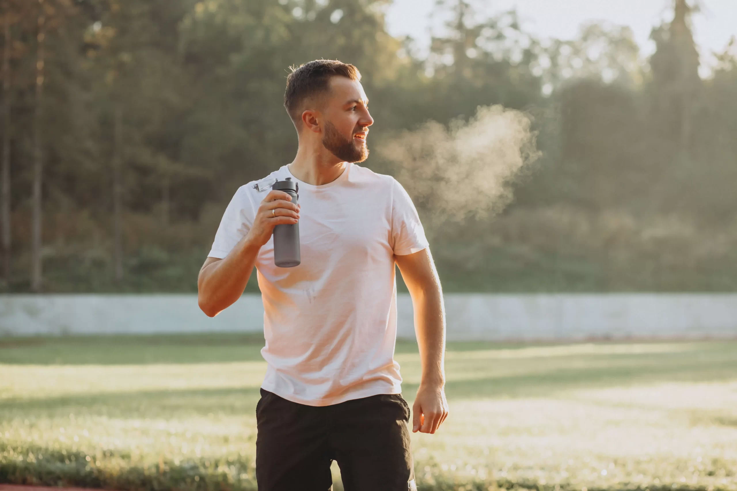 Athletic man wearing a white t-shirt and black shorts standing outdoors - best testosterone booster for males over 40