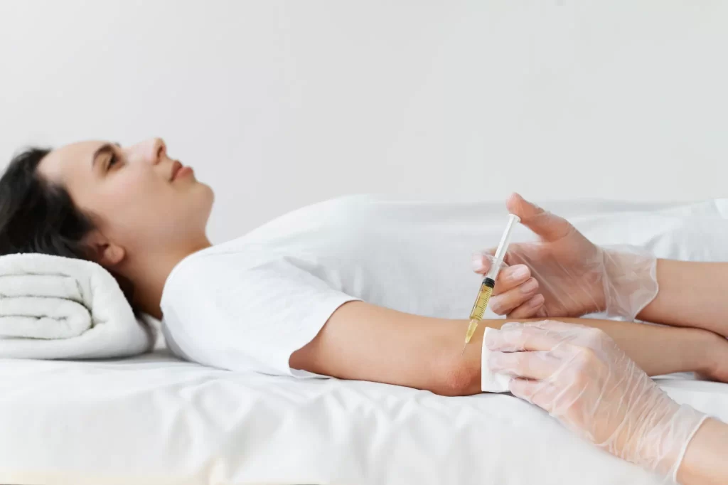 Medical professional administering an injection into a patient’s arm | Exosome therapy
