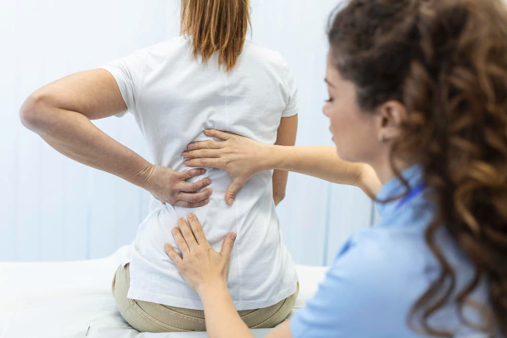 Physical therapist checking lower back pain